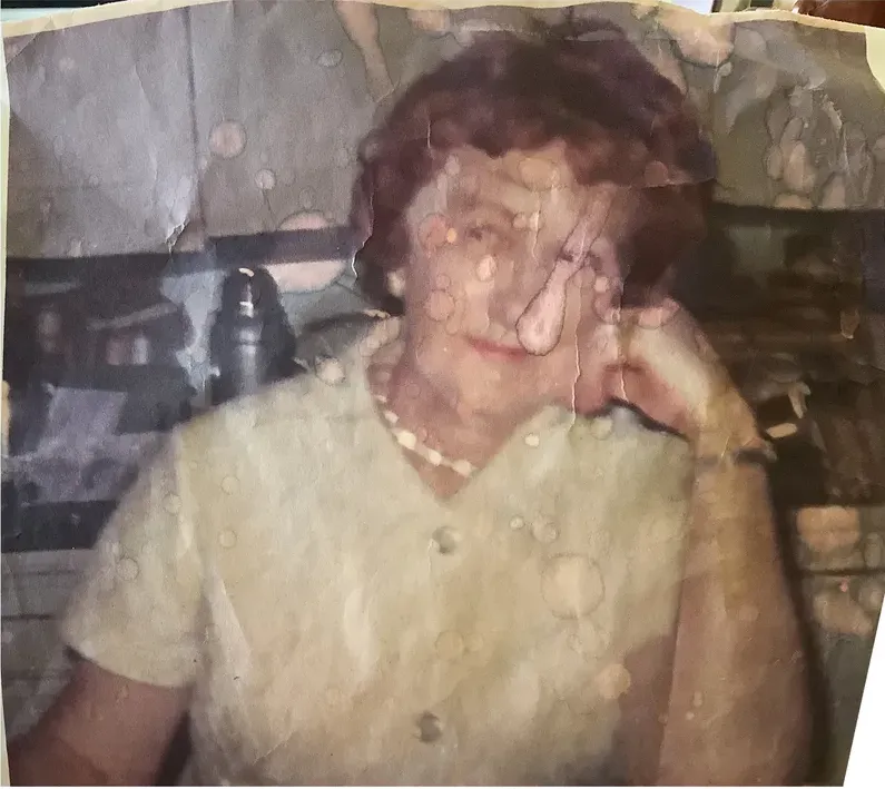 Water damage on a 1950s-1970s photograph, before hand restoration by MemoryCherish artists