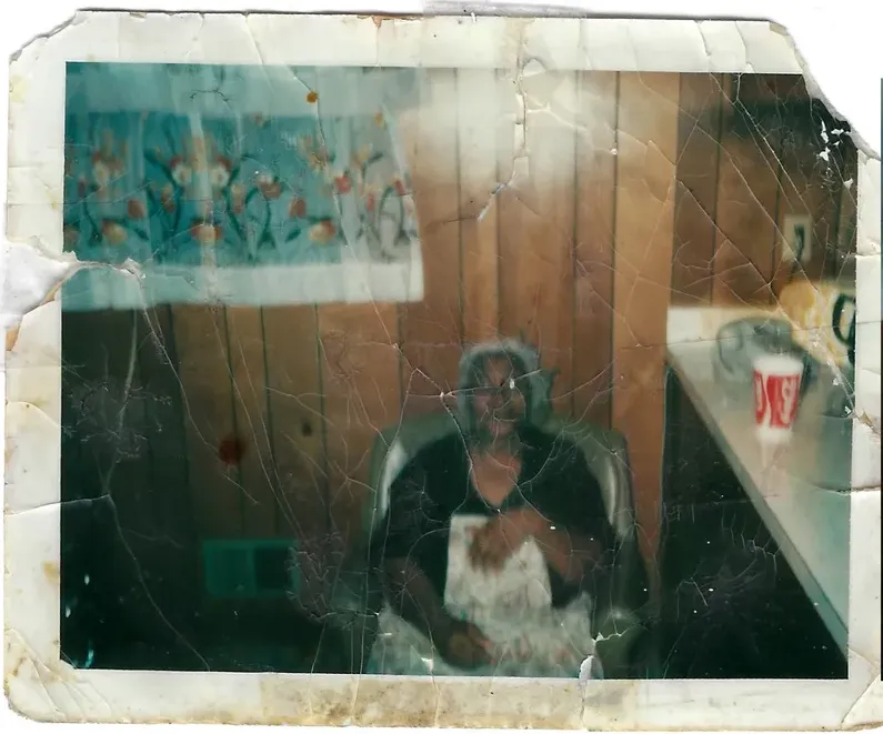 Water damage on a 1950s-1970s photograph, before hand restoration by MemoryCherish artists