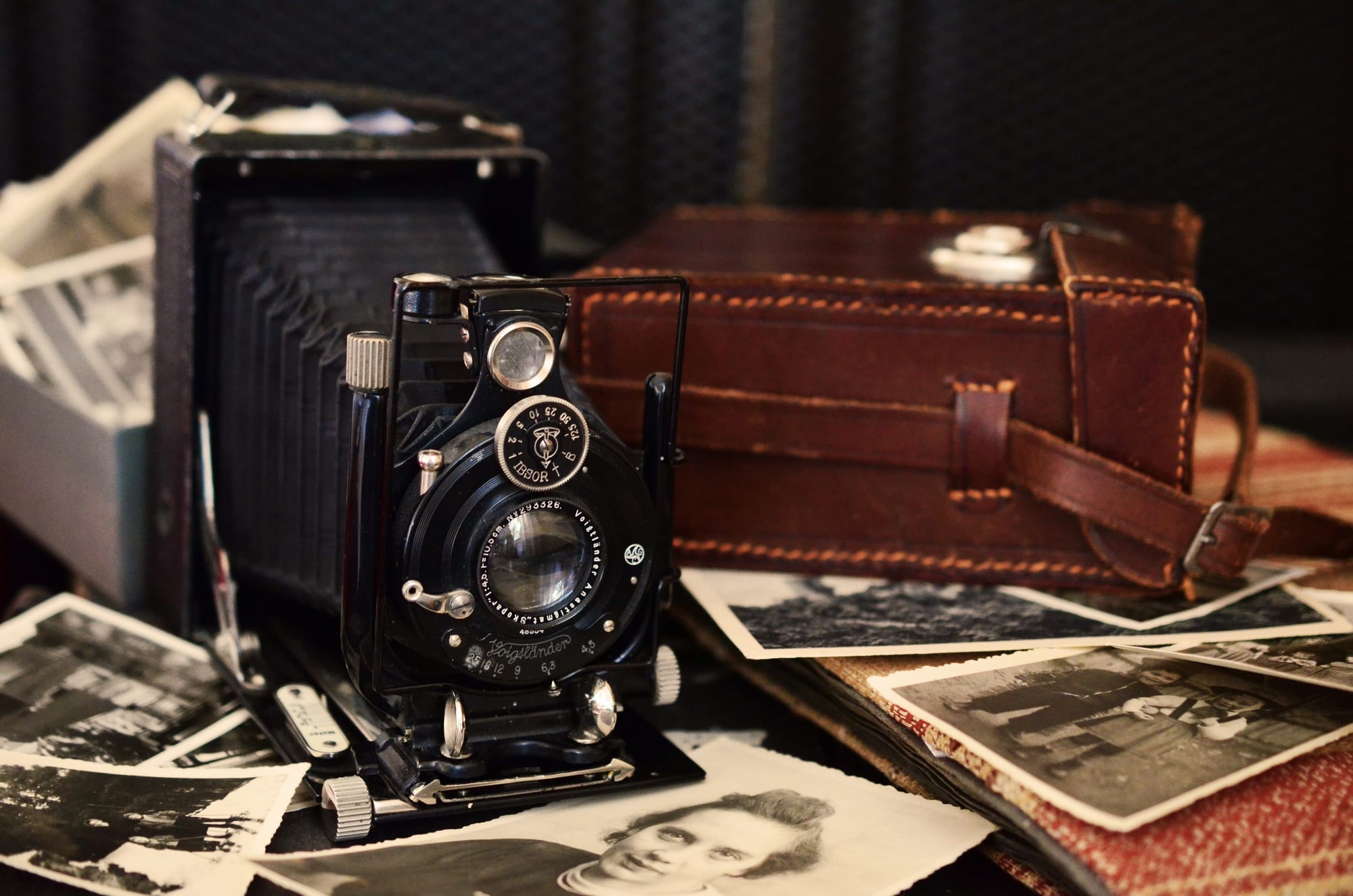 Free Black Folding Camera Beside Brown Bag on Grayscale Photos Stock Photo
