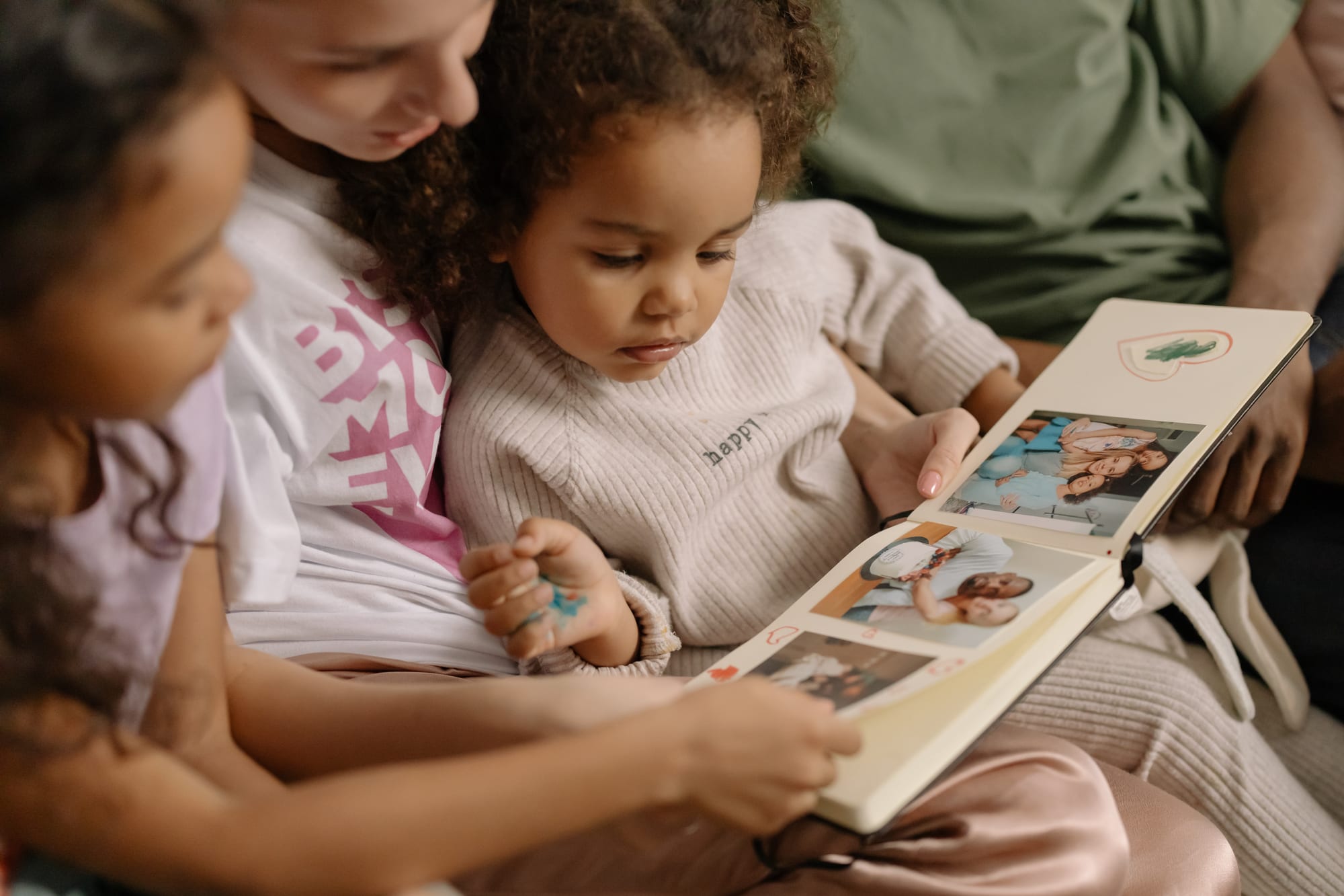 Free Mother with Daughters Looking at a Photo Album Stock Photo
